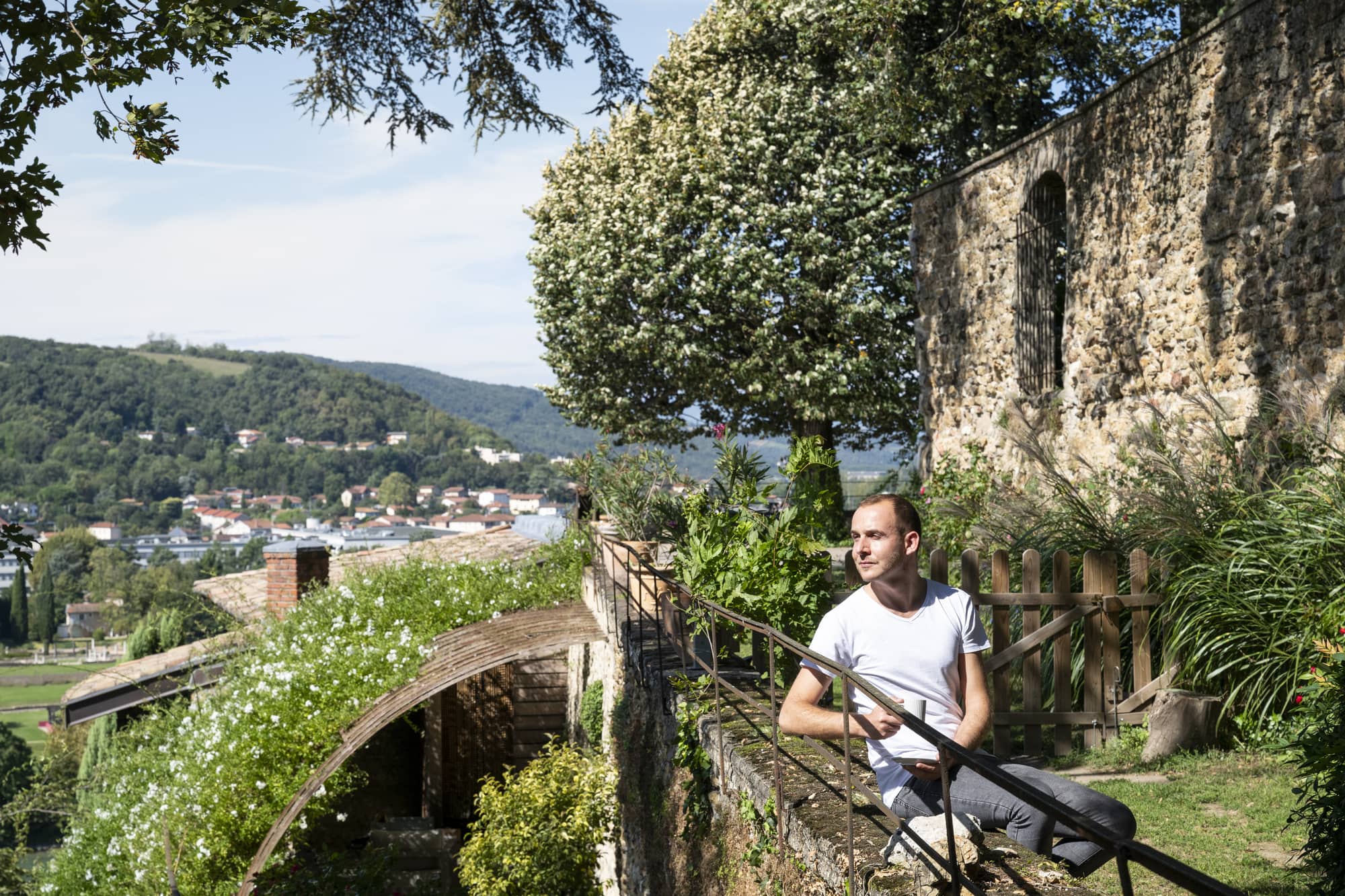 homme posé dans un jardin sur un muret