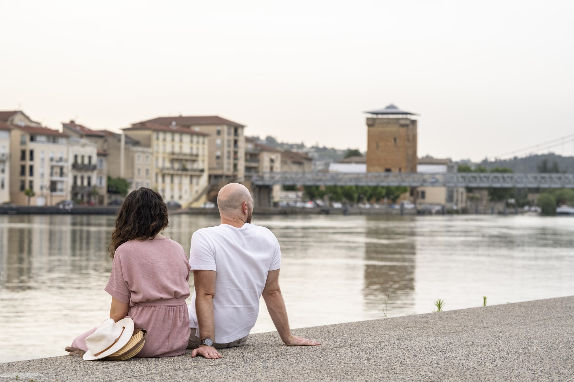 couple assis en bord de fleuve en ville